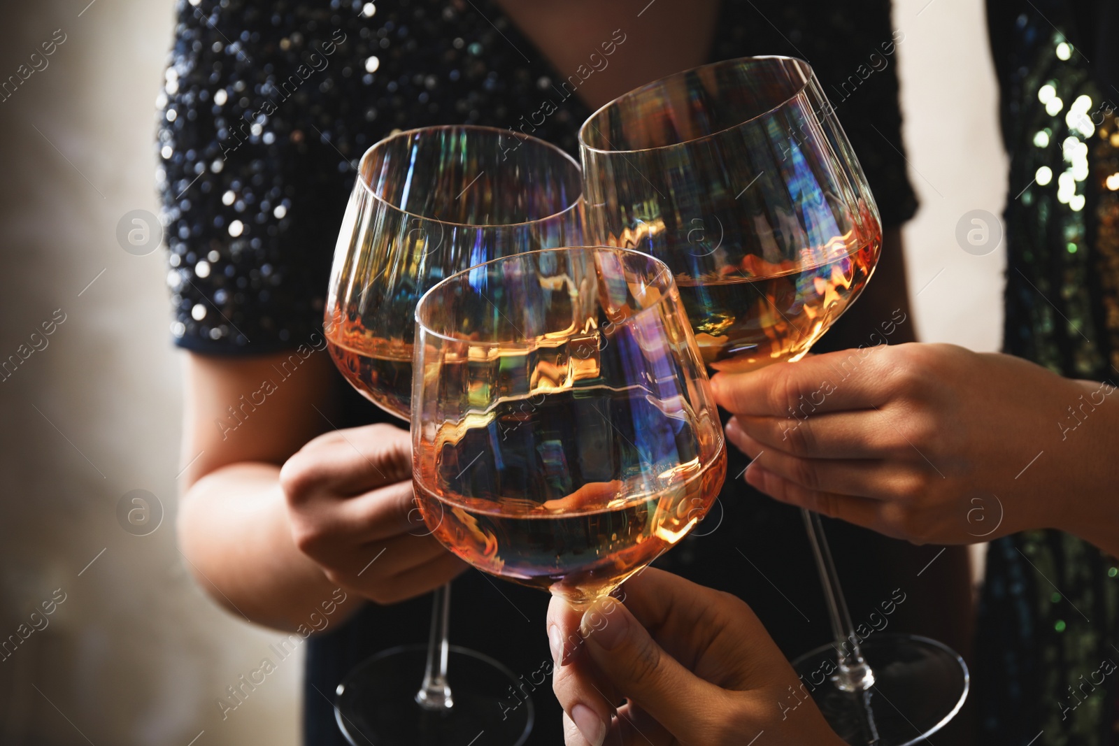 Photo of Women clinking glasses with white wine, closeup