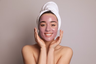 Photo of Woman with pomegranate face mask on grey background