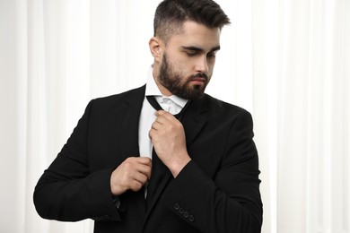 Handsome businessman in suit and necktie indoors
