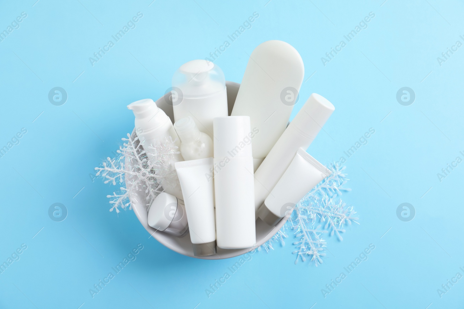 Photo of Set of cosmetic products on blue background, top view. Winter care