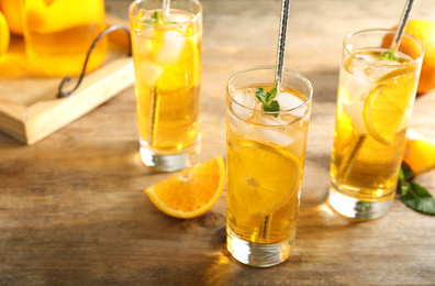 Photo of Delicious refreshing drink with orange slices on wooden table