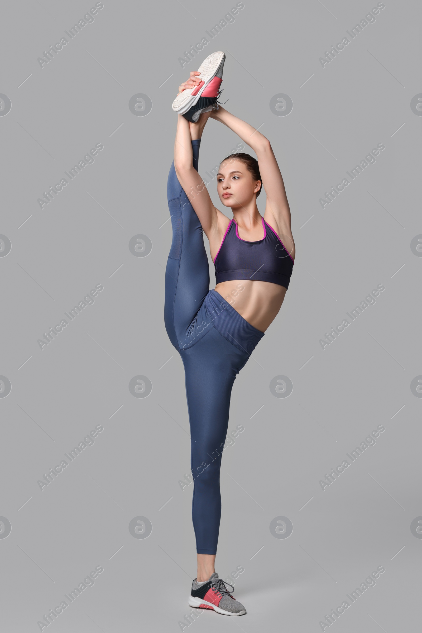 Photo of Woman stretching on grey background. Training exercise