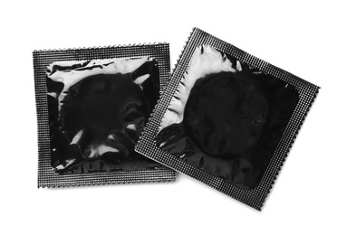 Image of Black condom packages on white background, top view. Safe sex