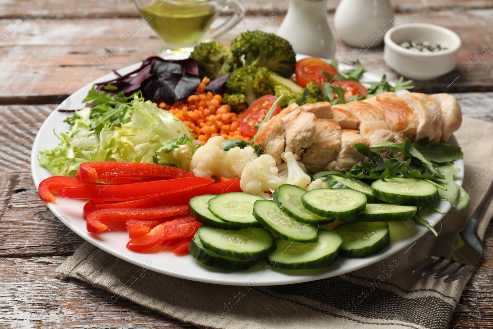 Photo of Balanced diet and healthy foods. Plate with different delicious products on wooden table, closeup