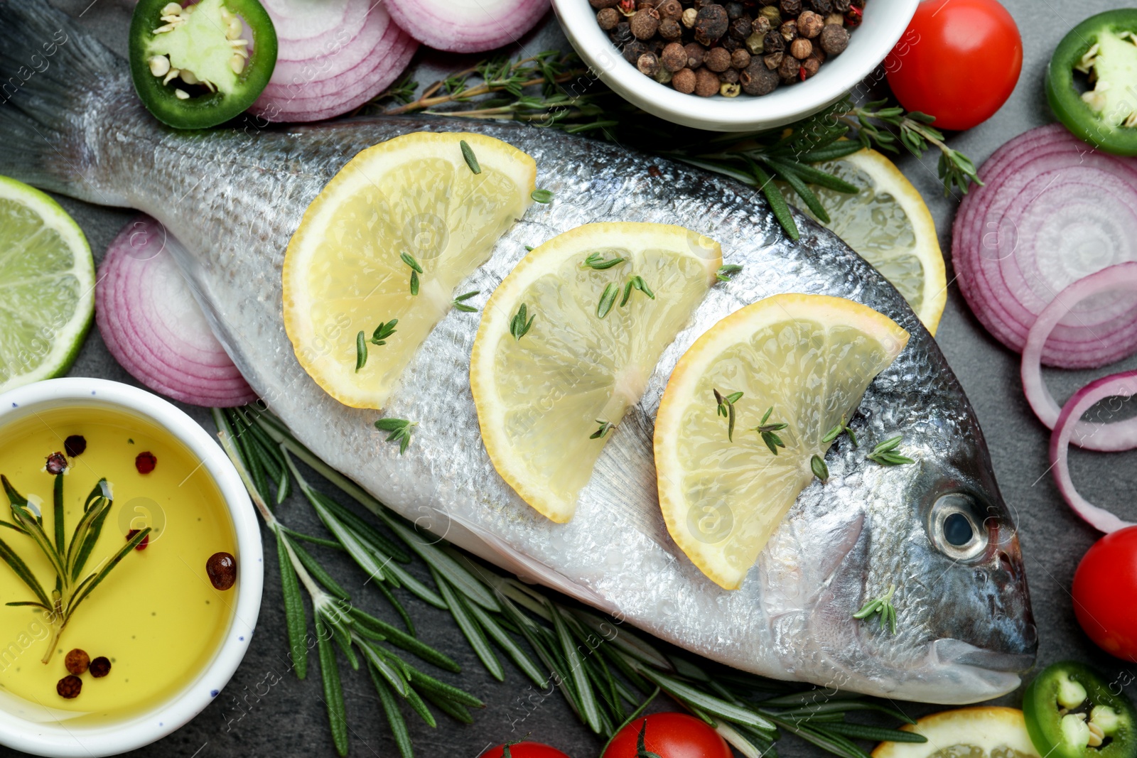 Photo of Fresh dorado fish and spices on black table, flat lay