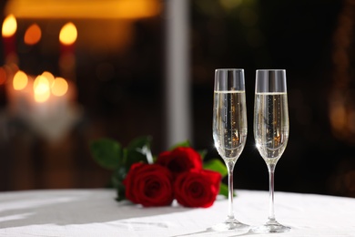 Photo of Glasses of champagne on table in restaurant, space for text. Romantic dinner