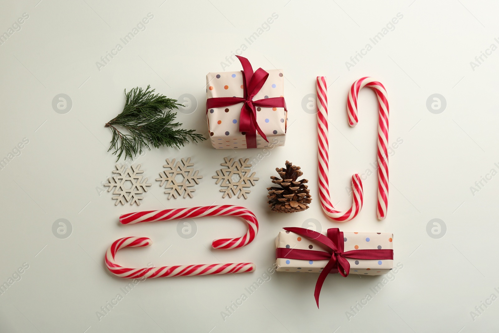 Photo of Flat lay composition with candy canes and Christmas decor on beige background