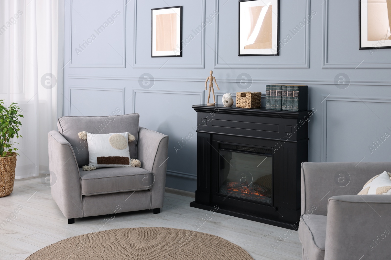 Photo of Black stylish fireplace near armchair in cosy living room