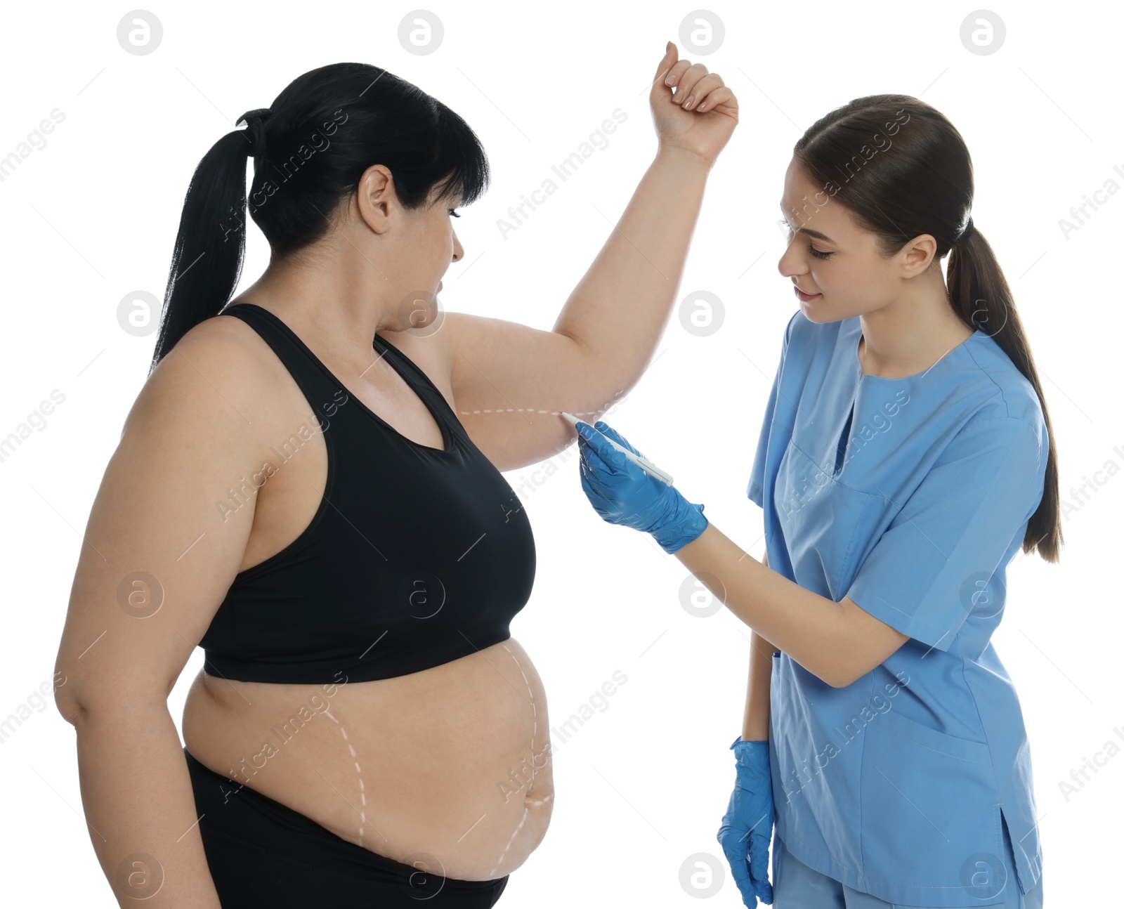 Photo of Doctor drawing marks on obese woman's body against white background. Weight loss surgery