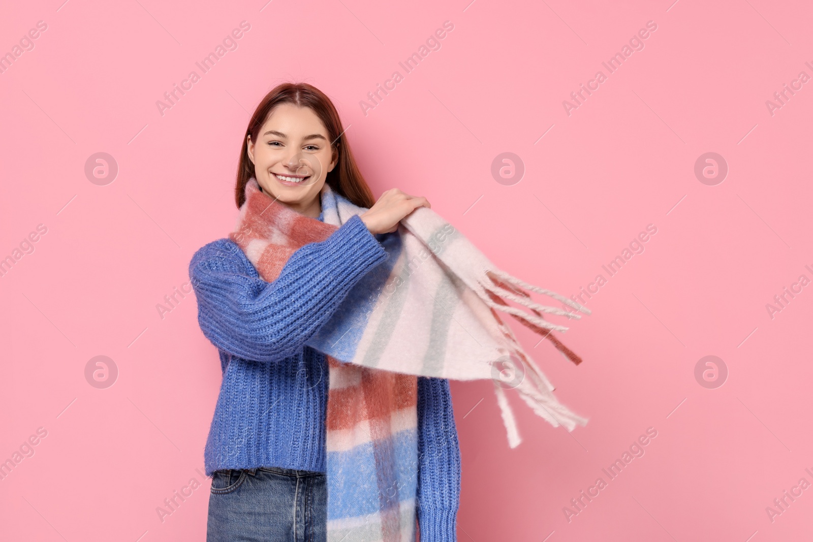 Photo of Beautiful woman in warm scarf on pink background, space for text