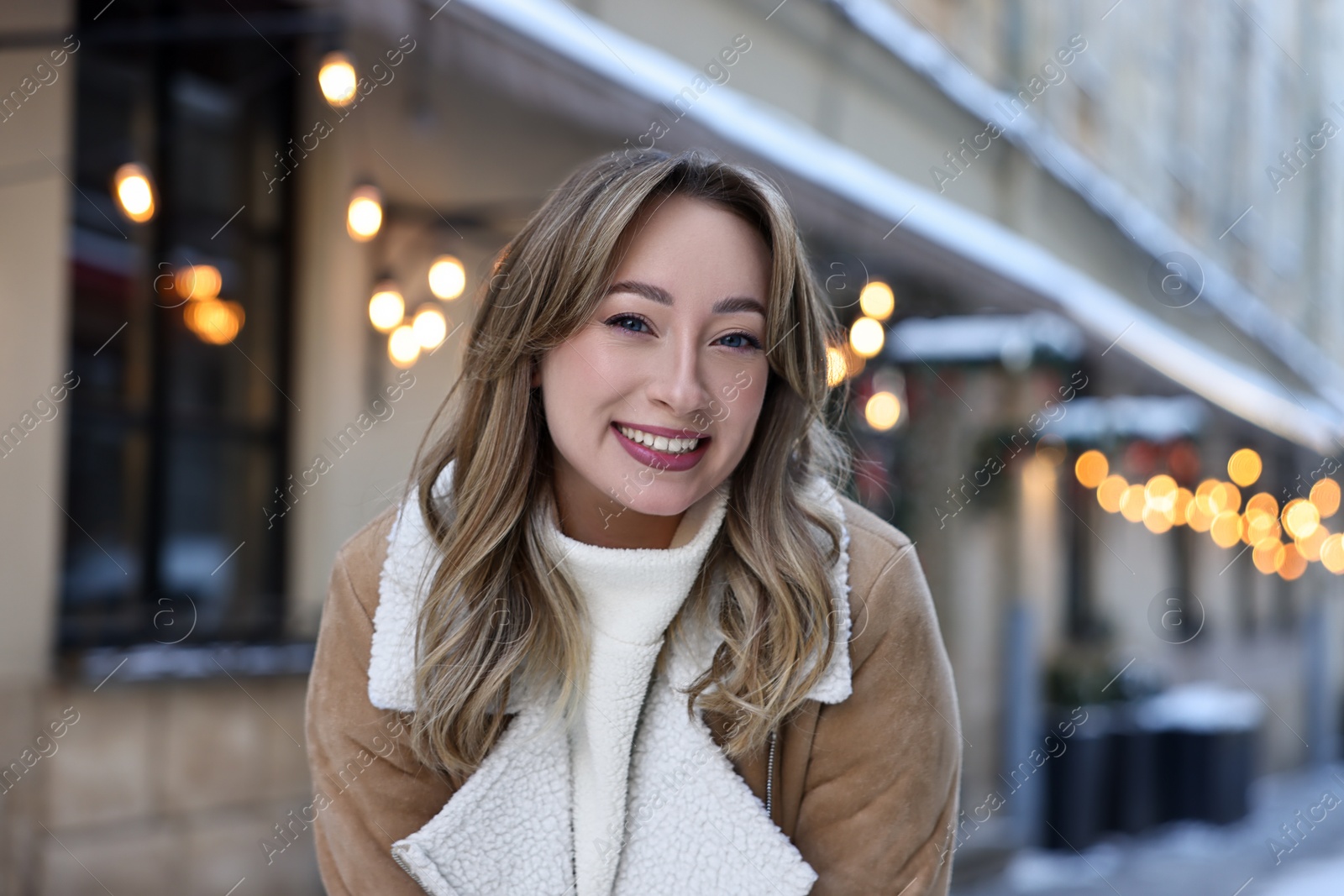 Photo of Portrait of smiling woman on city street in winter