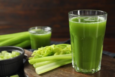 Glasses of delicious celery juice and vegetables on wooden board, closeup. Space for text