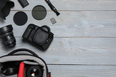 Photo of Professional photography equipment and backpack on grey wooden table, flat lay. Space for text