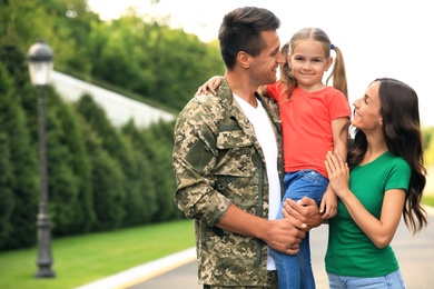 Man in military uniform with his family  at sunny park