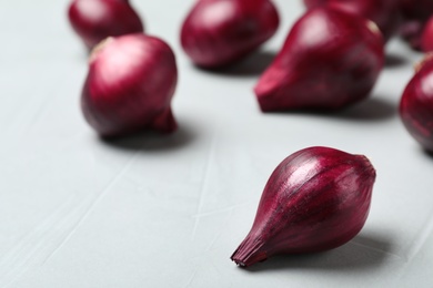 Fresh ripe red onions on grey table