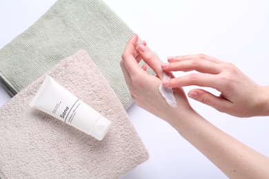 Photo of Woman applying hand cream on white background, above view