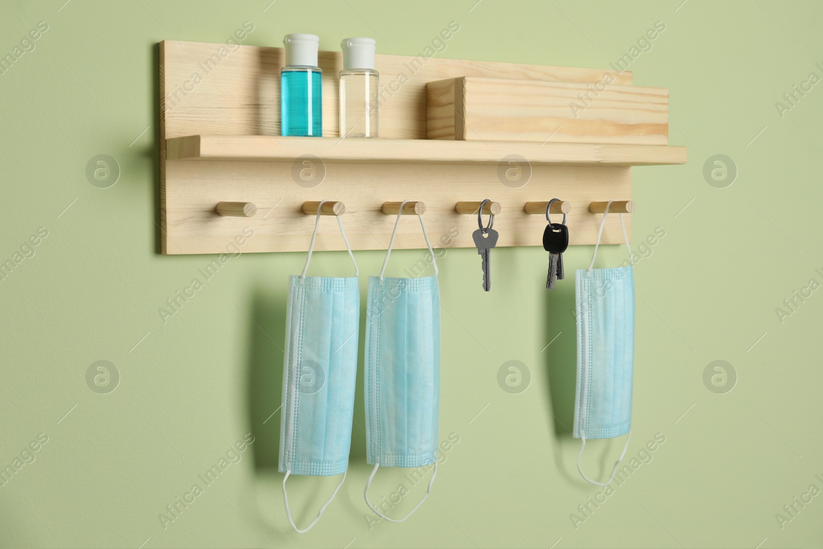 Photo of Wooden hanger for keys on light green wall