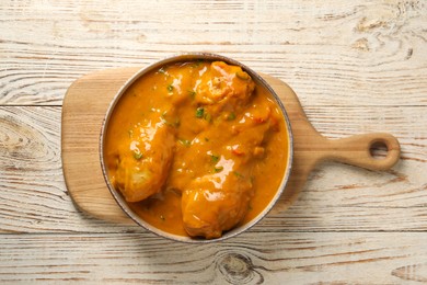 Tasty chicken curry on wooden table, top view