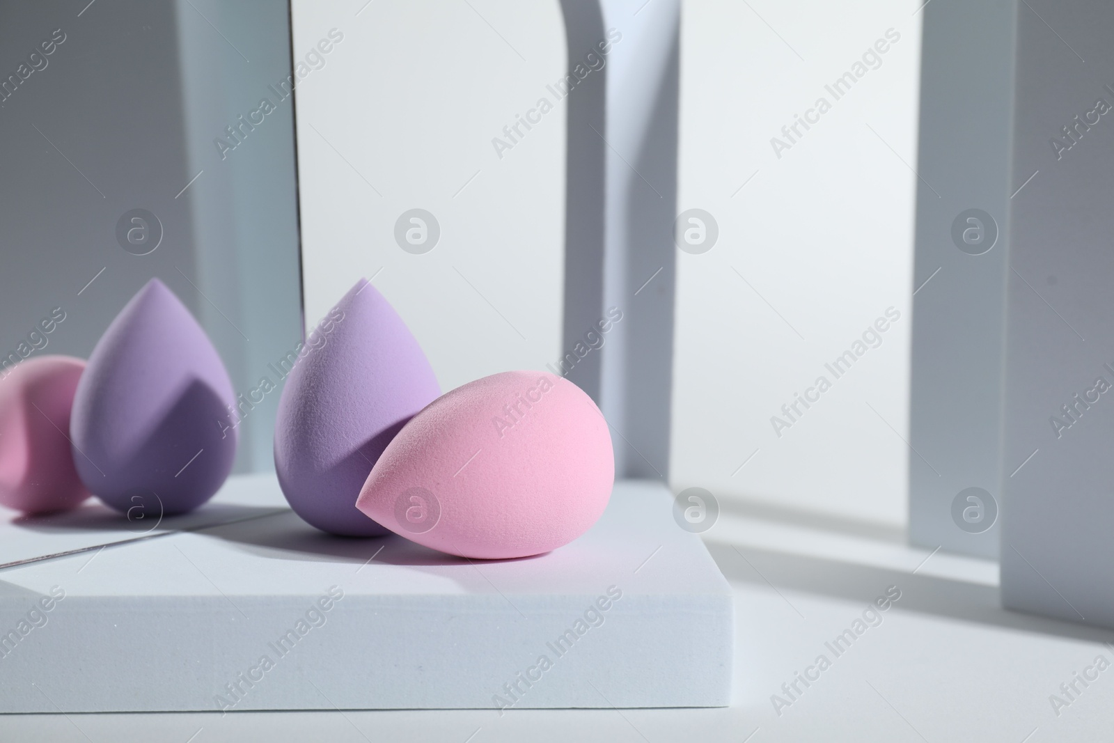 Photo of Stylish presentation of makeup sponges on white background