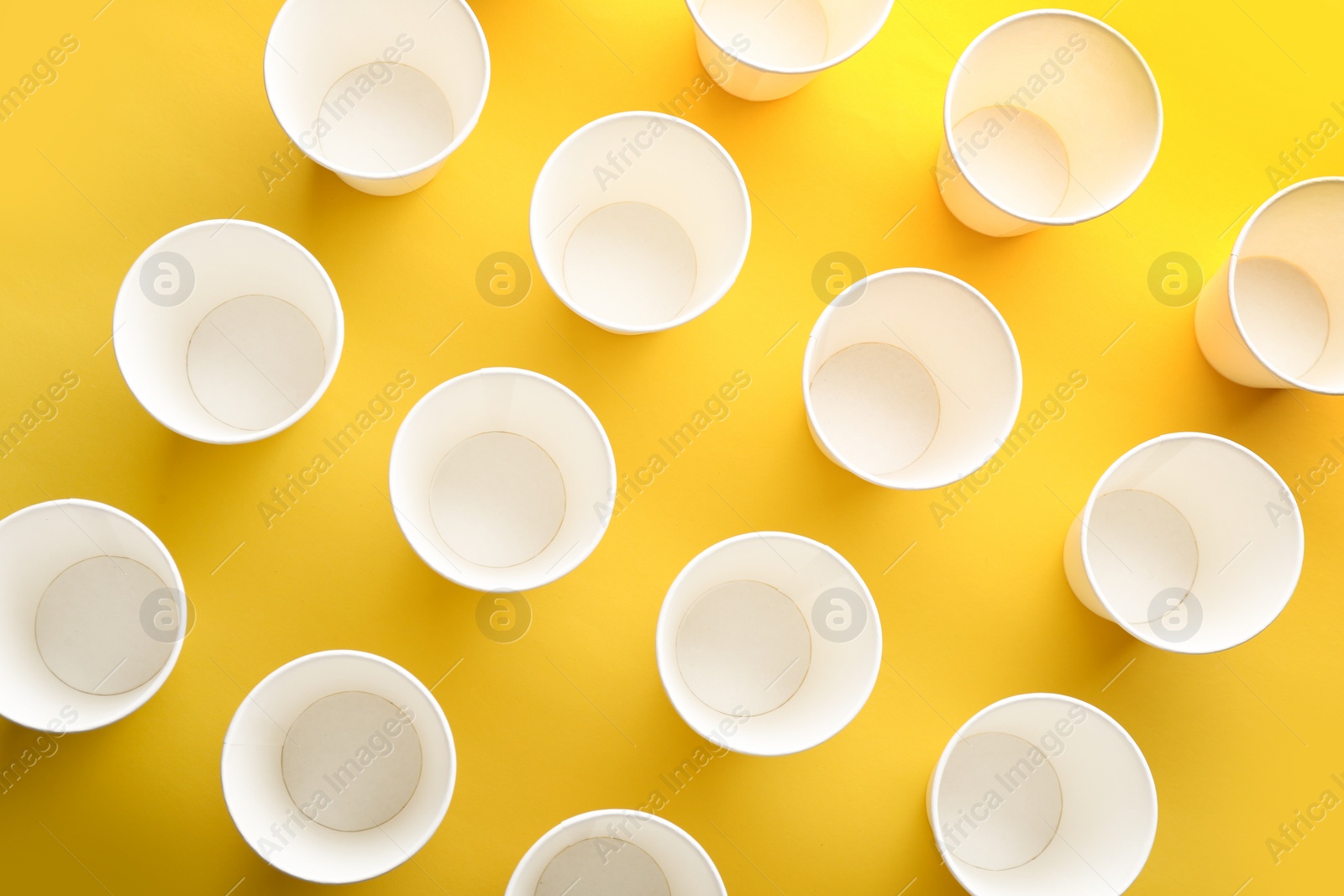 Photo of Paper cups on color background, top view. Picnic table setting