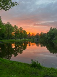 Photo of Picturesque view of pond at bright sunset