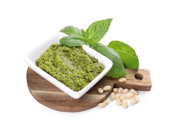 Photo of Fresh tasty pesto sauce, pine nuts and basil isolated on white