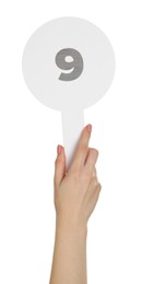 Woman holding auction paddle with number 9 on white background, closeup