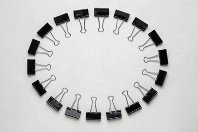 Photo of Binder clips on light background, flat lay. Space for text