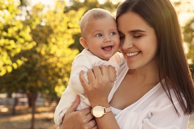 Photo of Young mother with her cute baby in park on sunny day