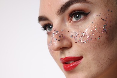 Photo of Beautiful woman with glitter freckles on white background, closeup. Space for text