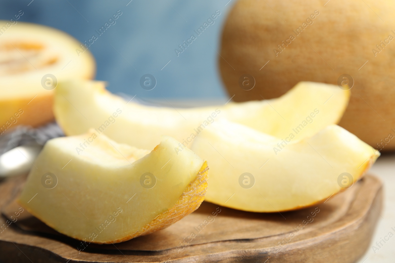 Photo of Wooden board with slices of ripe melon on table, closeup