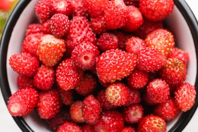 Fresh wild strawberries in mug, top view