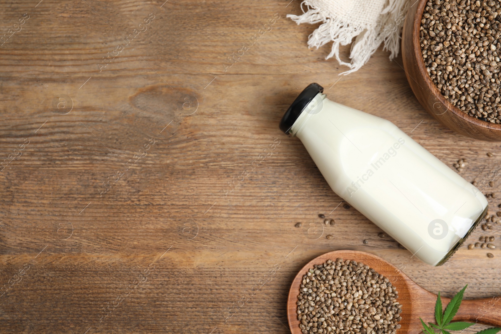 Photo of Flat lay composition with fresh hemp milk on wooden table. Space for text