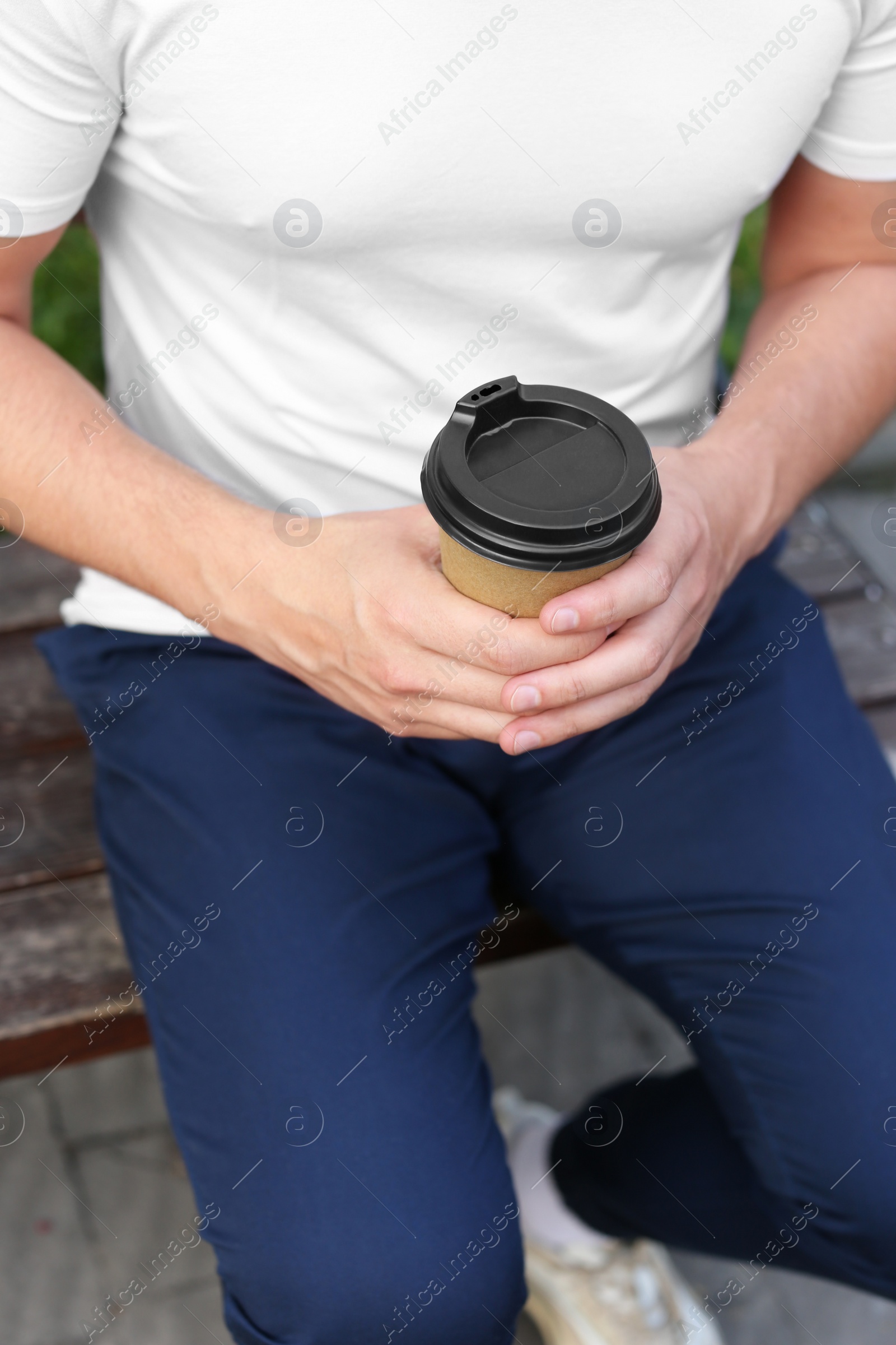 Photo of Coffee to go. Man with paper cup of drink outdoors, closeup