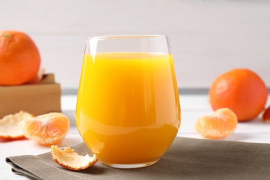 Photo of Glass of fresh tangerine juice on table