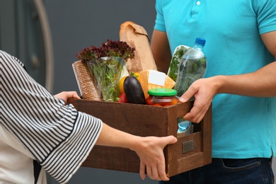 Male courier delivering food to client indoors, closeup