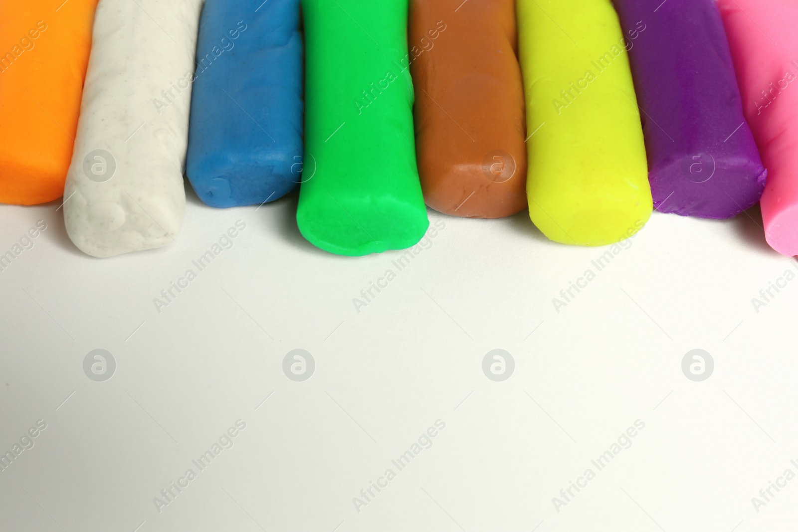 Photo of Different color play dough on white background, closeup