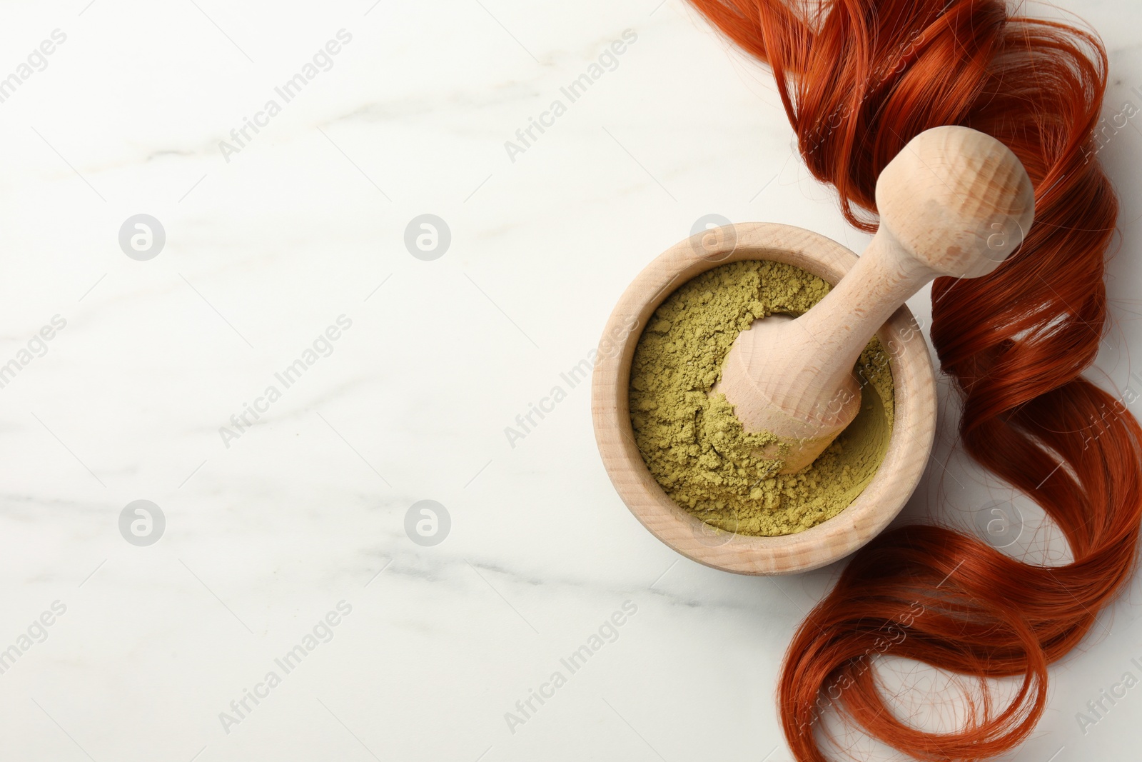 Photo of Mortar of henna powder and red strand on white marble table, flat lay with space for text. Natural hair coloring