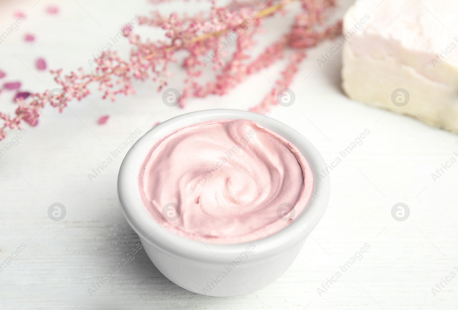 Photo of Professional face mask with flowers on white wooden table