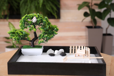 Beautiful miniature zen garden on wooden table indoors