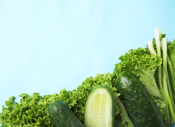 Photo of Flat lay composition with fresh salad ingredients on light blue background, space for text