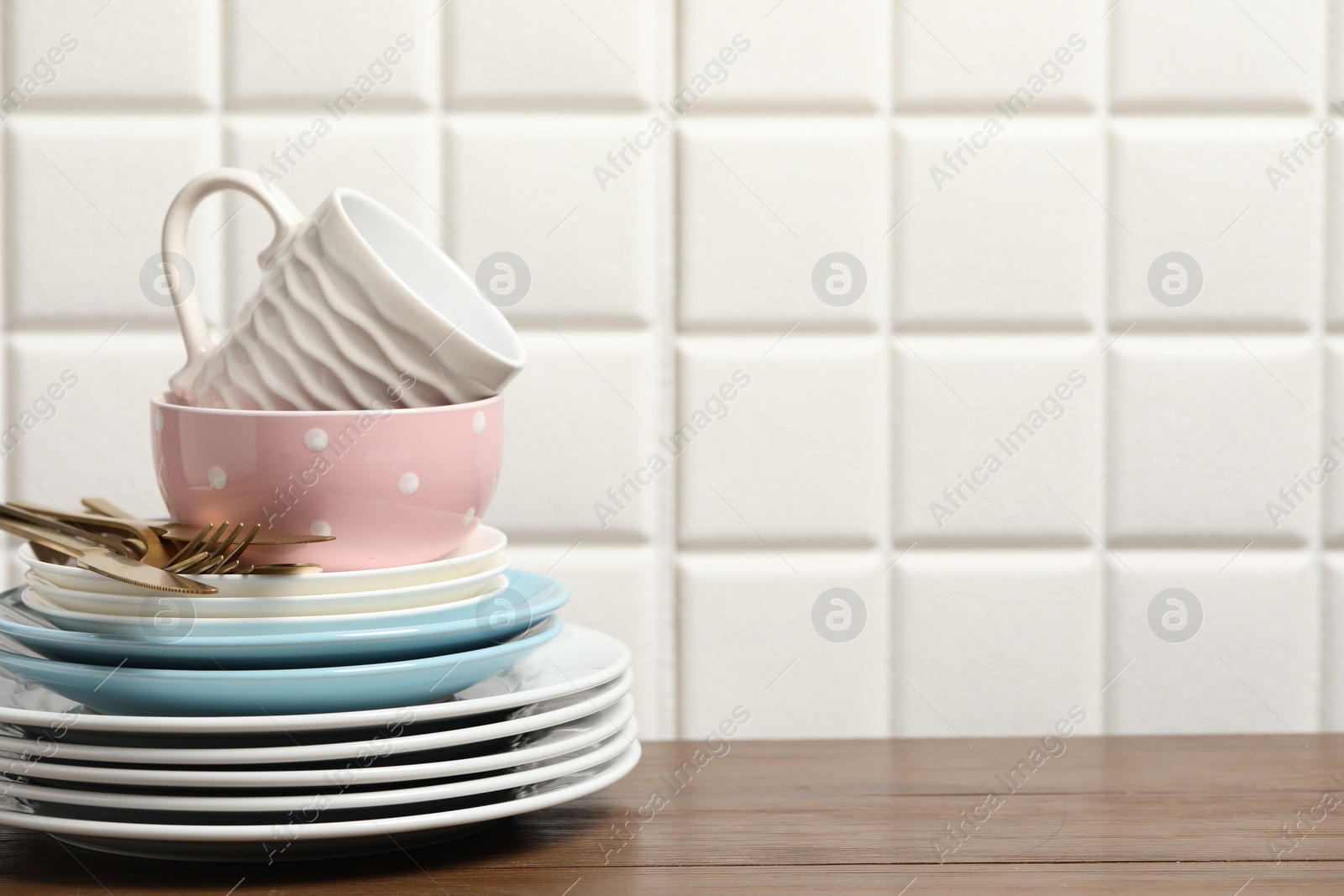 Photo of Beautiful ceramic dishware, cup and cutlery on wooden table, space for text