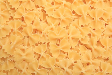 Photo of Raw farfalle pasta as background, top view