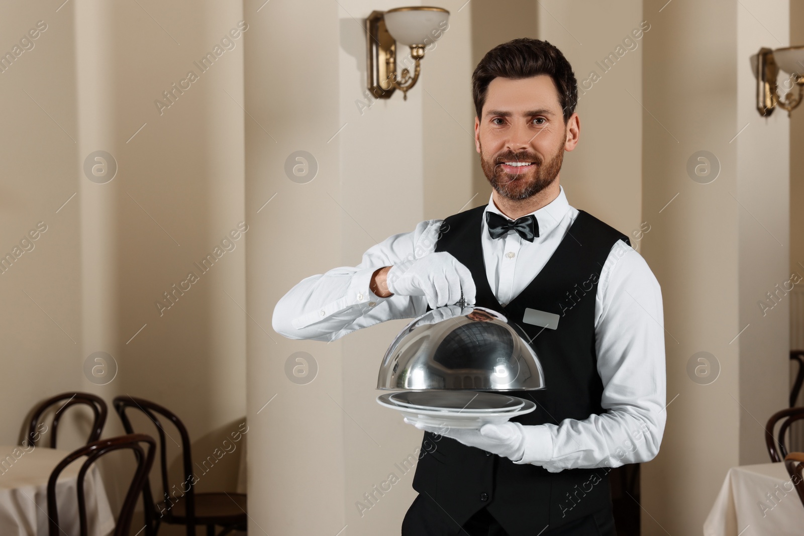 Photo of Man setting table in restaurant. Professional butler courses