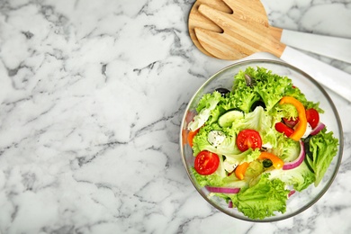 Photo of Tasty fresh Greek salad on white marble table, flat lay. Space for text
