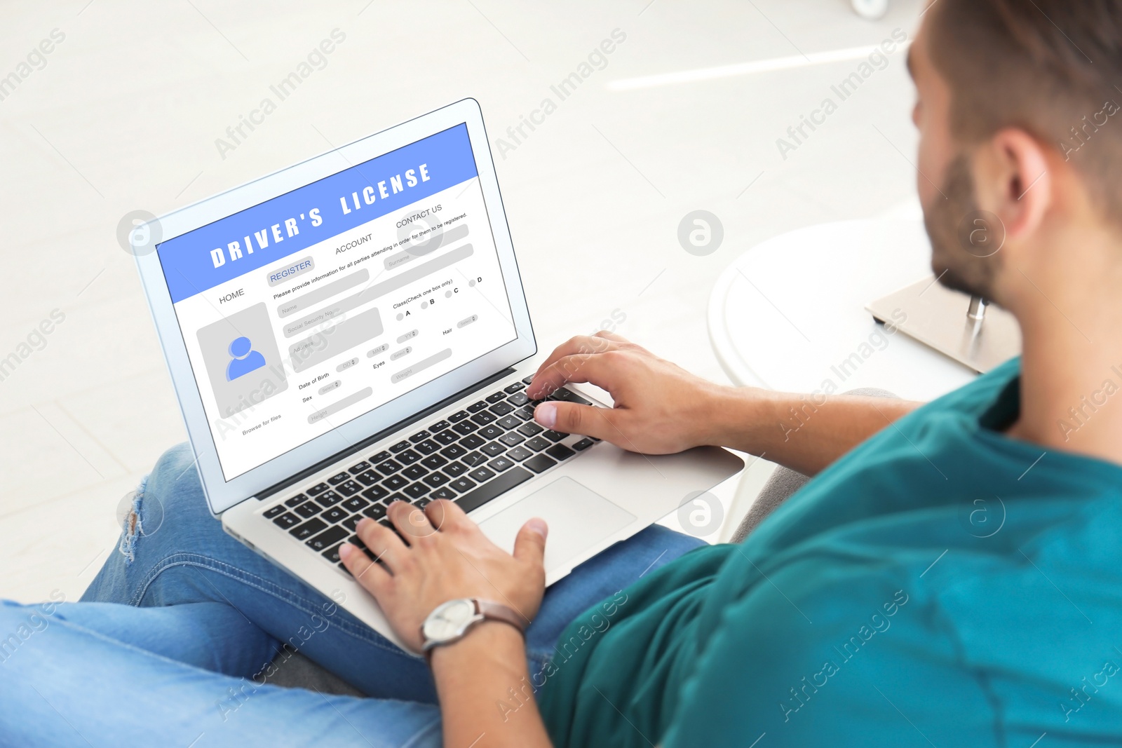 Image of Man filling in driver's license form online on website using laptop
