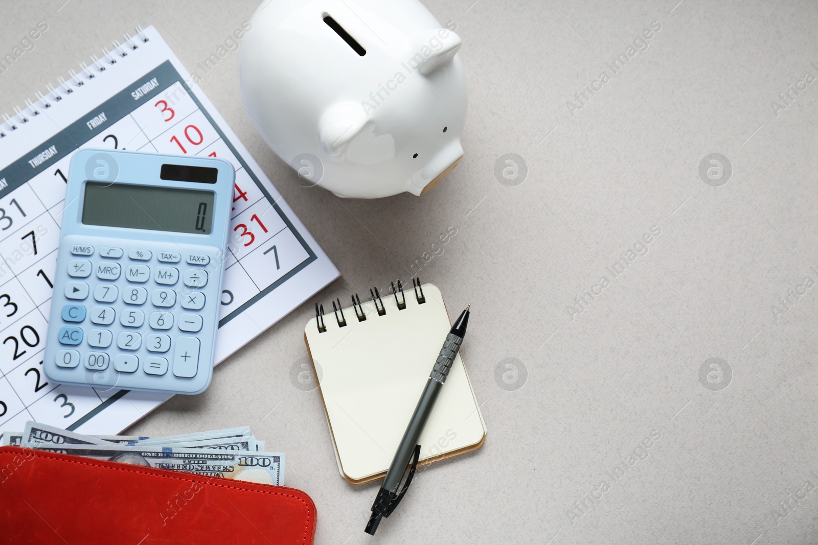 Photo of Flat lay composition with piggy bank and calculator on light grey background. Space for text