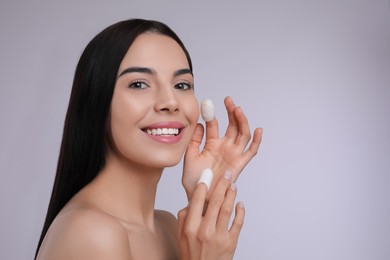 Photo of Woman using silkworm cocoons in skin care routine on light grey background. Space for text