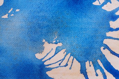 Abstract blue watercolor painting on white paper, top view