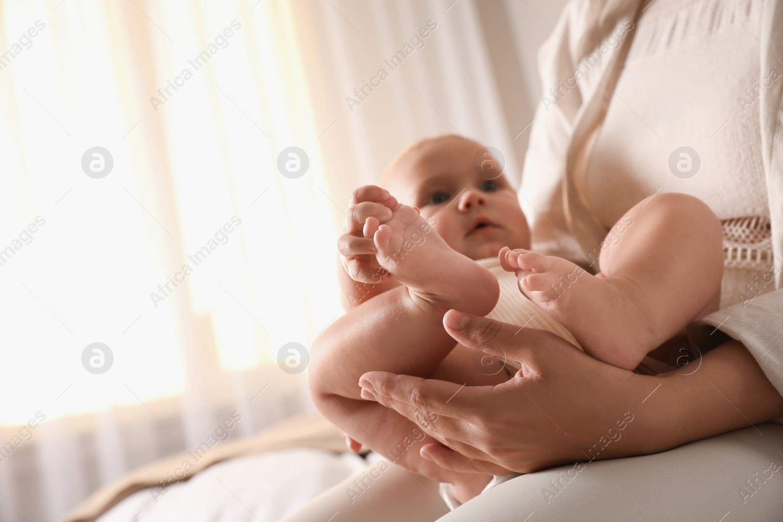 Photo of Young woman and her cute baby indoors, focus on feet. Lullaby songs